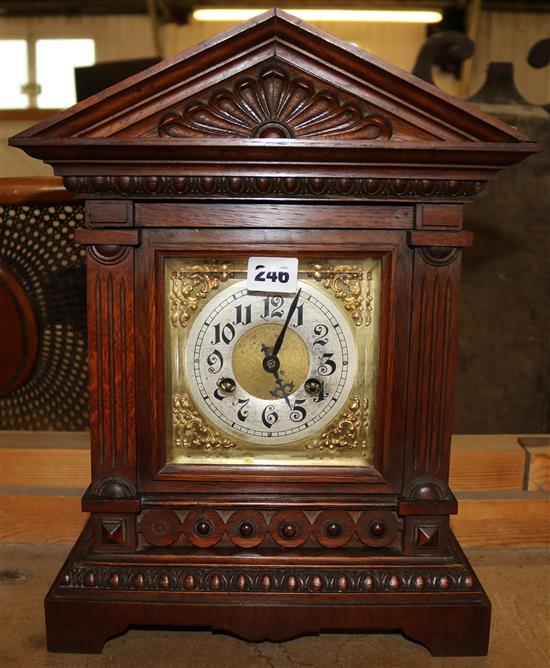 German carved oak mantel clock, with silvered dial and brass spandrels in architectural case